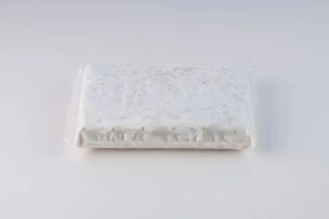 Raw tempeh in plastic wrap Stock Photos