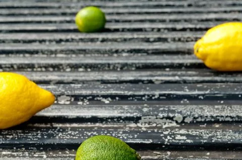 Raw textured black  Background backdrop with lemon and lime and copy space Stock Photos