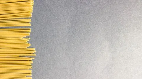 Raw thin spaghetti on a black background. Frame, space for text. Stock-Fotos