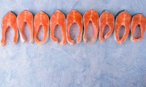 Raw trout steak pattern on a blue background top view Stock Photos