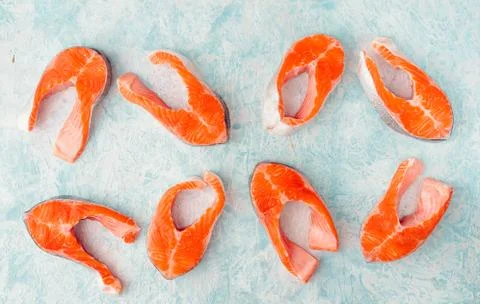 Raw trout steak pattern on a blue background top view Stock Photos
