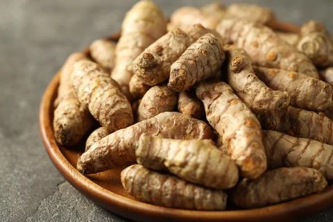 Raw tumeric rhizomes on grey table, closeup Stock Photos