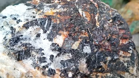 Raw Tungsten Ore Close-Up with Blurred Blue-Green Copper Minerals Behind Stock Footage 314315886