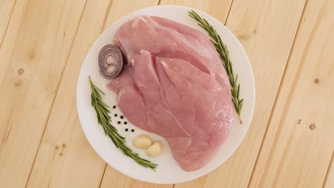 Raw turkey fillet rotating with spices Stock Footage 337441476