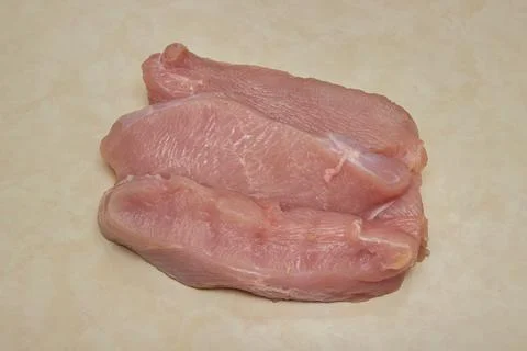 Raw turkey steaks on the kitchen table. Turkey breast fillet. Stock Photos