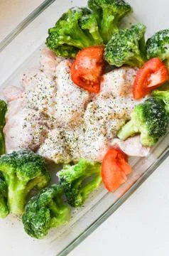 Raw turkey with vegetables on a baking sheet. cauliflower spomidora. Dish wit Foto stock