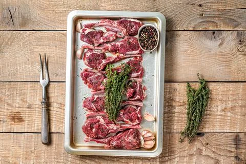 Raw uncooked lamb mutton meat chops steaks with thyme and garlic. Wooden Stock Photos