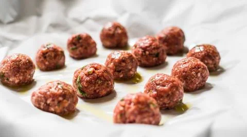 Raw uncooked meatballs on a baking sheet Stock Photos