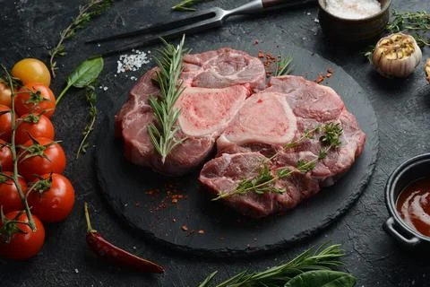 Raw veal Ossobuko steak with bone. Meat. On a stone background. Stock Photos