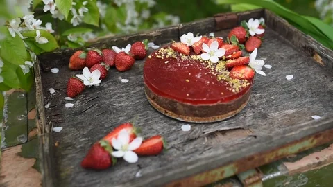 Raw vegan cake with strawberries viewed from the side on table Video stock 88691012