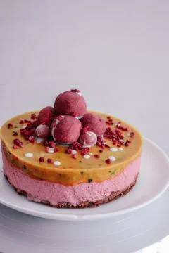 Raw vegan raspberry cake decorated with berry truffles. Mango filling jelly Stock-Fotos