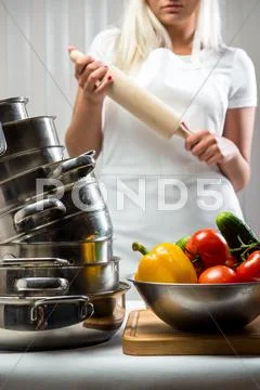 Raw vegetables with kitchen utensil and woman holding rolling-pin Stock Photos