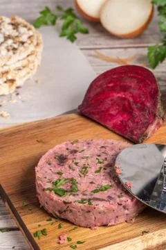 Raw veggie burger with beetroot and white beans with parsley leaves on wood c Foto stock