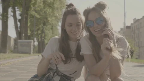 Raw video. Two young beautiful smiling hipster girls Stock Footage 142375636