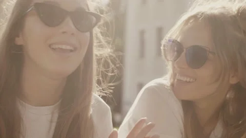 Raw video. Two young beautiful smiling hipster girls in trendy summer clothes Stock Footage 142378115