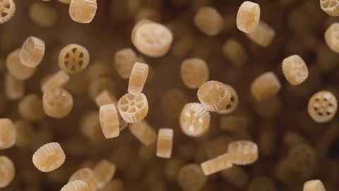 Raw wagon wheels pasta flies after being exploded. Slow Motion. Stock Footage 76230785