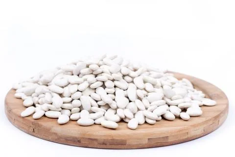Raw white beans on the kitchen board. Copy space white background Stock Photos
