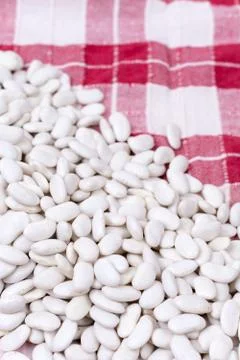 Raw white beans on the kitchen table cloth Stock Photos