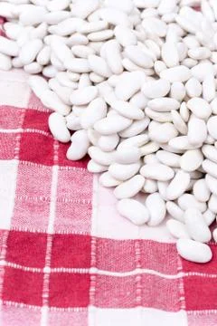 Raw white beans on the kitchen table cloth Stock Photos