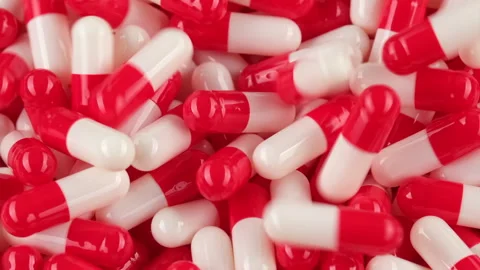 Raw white capsules pills falling down, zoom frame Stock Footage 253574137