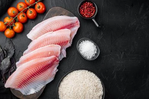 Raw white fish tilapia with basmati rice and cherry tomatoes ingredients, on  Stock Photos