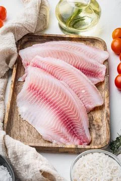Raw white fish tilapia with basmati rice and cherry tomatoes ingredients, on  Foto stock