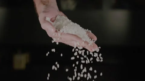 Raw White Rice Falling From Hands on a dark background. Video stock 228065464