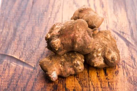 Raw Whole ans sliced Jerusalem artichokes on a cutting board Stock Photos