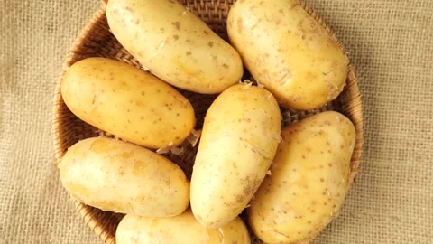 Raw whole potatoes rotating in a wicker basket. Stock Footage 335436456
