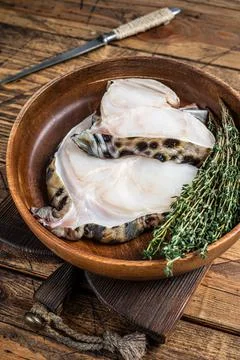 Raw wolffish or wolf fish fillet in a wooden plate. wooden background. Top view Stock Photos