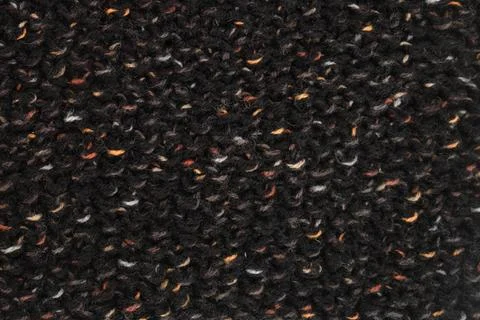 Raw wool fabric texture for winter clothing. Black knitted sweater surface wi Foto stock