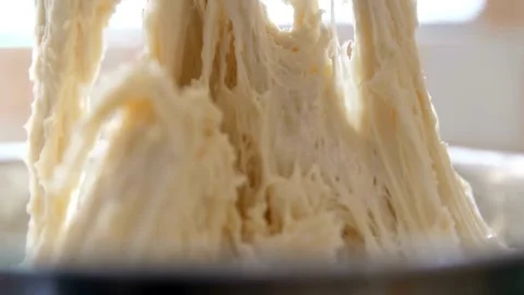 Raw yeast dough is pulled and stretched in bowl Stock Footage 332281370