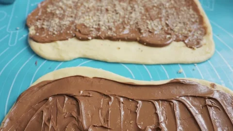 Raw Yeast Dough Spread with Chocolate Hazelnut Cream and Chopped Nuts on Mat Stock Footage 333822173