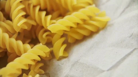 Raw yellow fusilli pasta lying on brown craft paper Stock-Footage 333831420