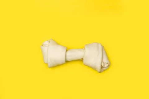 A rawhide bone on a yellow background with copy space Foto stock