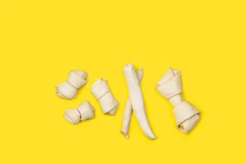 Rawhide bones on a yellow background with copy space Foto stock