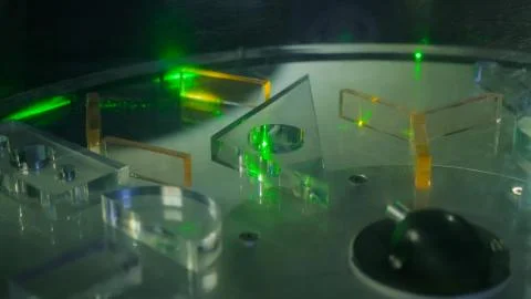 Ray of green laser lights through different transparent figures Stock Photos