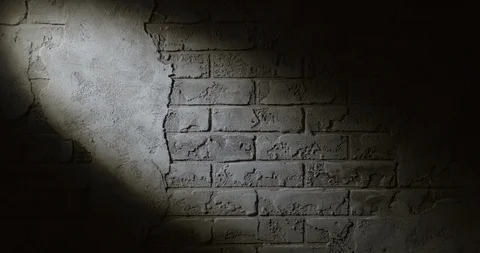 Ray of a lantern on an old brick wall in a dark room. Stock Footage 94911597