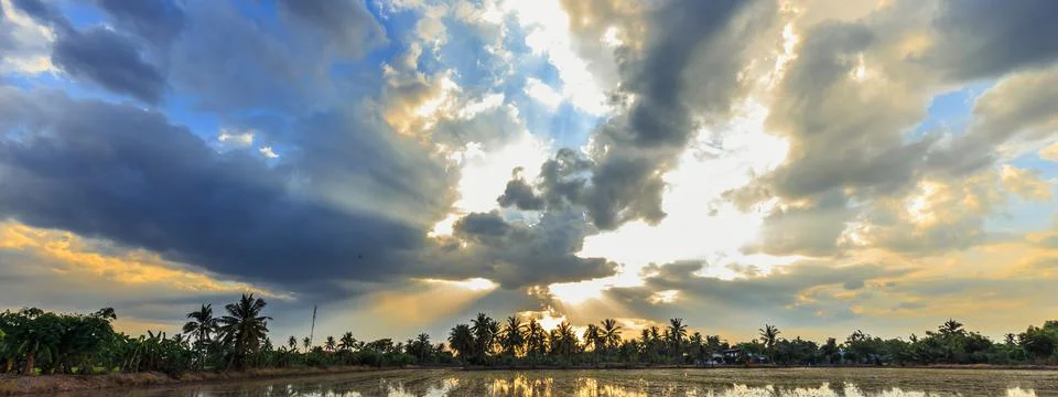 Ray of light breaks through the dramatic sky at sunset Stock Photos