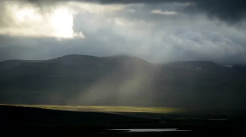 Ray of light in rain storm clouds high contrast mountain valley Iceland 4k Stock Footage 66033790