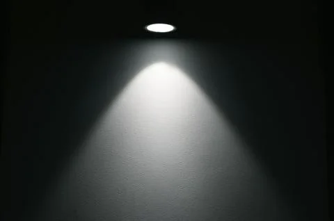 Ray of light from round compact lamp in dark room during night time Stock-Fotos