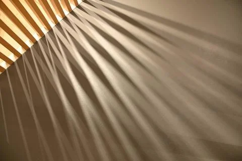  Ray lights through woodden pattern frame creating graphic shadows on gray... Foto stock