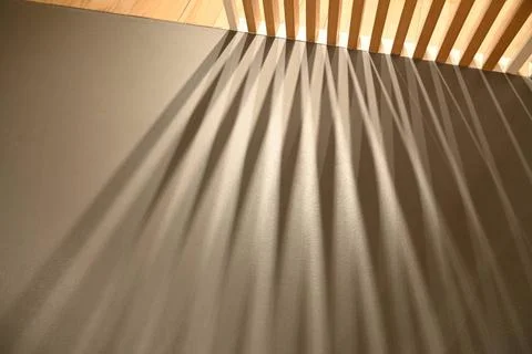  Ray lights through woodden pattern frame creating graphic shadows on gray... Foto stock