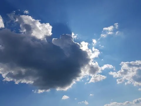 A ray of sun peeks through a dark cloud. Dark cloud in the sky. Sun from a cloud Stock Photos