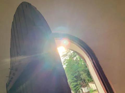 A ray of sunlight streams through an open arched doorway Stock Photos