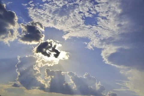 Ray tracing of the sun hidden behind a cloud in humid summer air Stock Photos