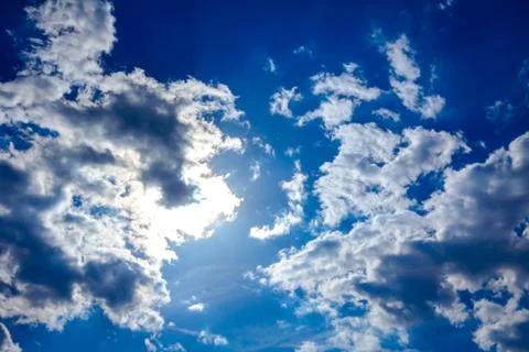 Rays on blue sky with cumulus clouds Stock Photos