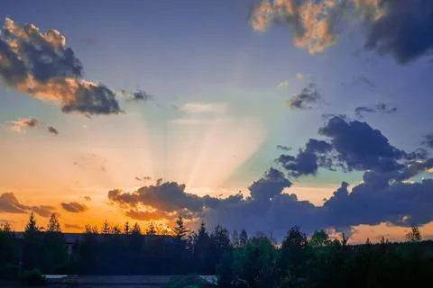 Rays break through the clouds during sunset Stock Photos