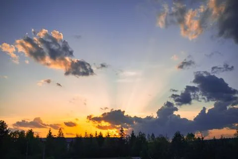 Rays break through the clouds during sunset Stock Photos