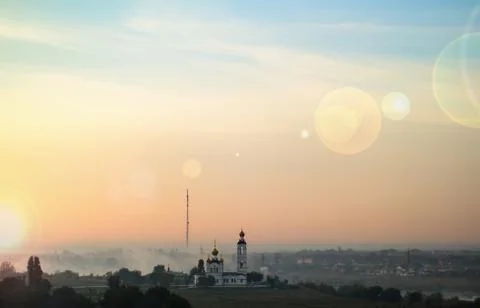 The rays of the dawn sun over the city and the morning fog Stock-Fotos